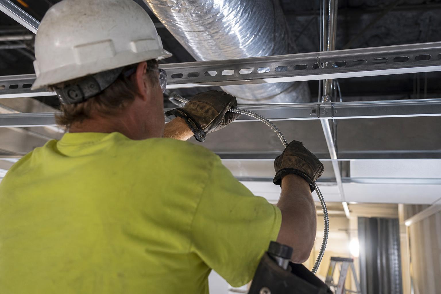Skilled tradeswoman wiring a commercial electrical panel